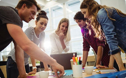 Young team collaborating around a table with laptop